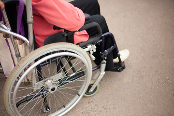 Obraz premium Elderly man in a wheelchair. Disabled for a walk. Problems with musculoskeletal system. Disease of the spine. Help for older people.