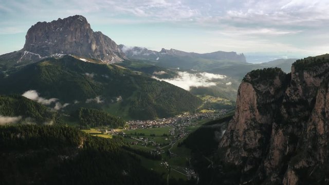 Beautiful mountain aerial view of Dolomite Alps and a small town during sunset