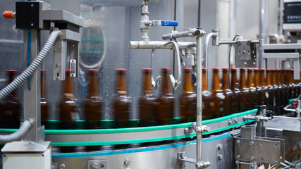 Beer bottles motion blur. Beer bottles on the conveyor belt. Shallow dof. Selective focus.