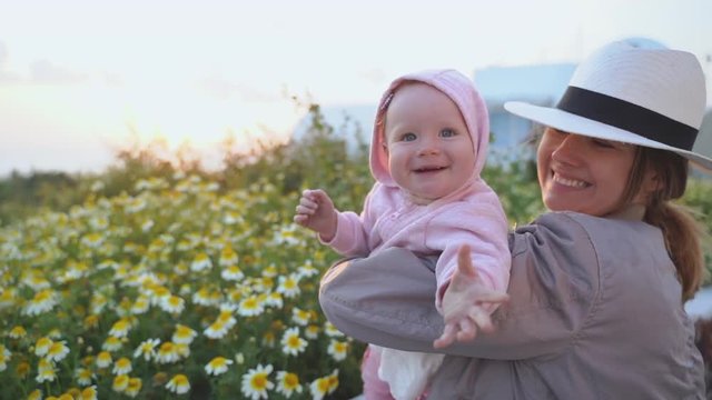 happy harmonious family outdoors. mother throws baby up, laughing and playing in the summer on the nature slow motion