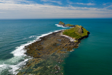 Aerial drone view of the rugged coastline and sea cliffs of Worm's Head at Rhossili on the Gower Peninsula of Wales