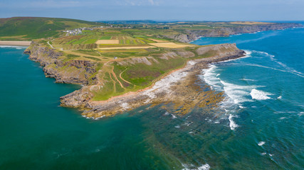 Naklejka premium Aerial drone view of waves breaking onto sea cliffs on a summers day