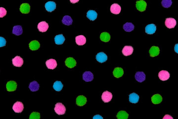 Multi-colored balls on a black background. Bright pink, blue, green and purple fluffy round balls. The concept of decoration, design wallpaper, covers.
