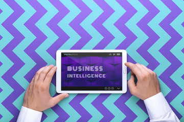 Man holds a tablet and looks at the screen. Mobile development. Innovational online businesses. Internet technologies. Trendy design. Geometry. Fashionable vibrant colors. Using a device. UX and UI.
