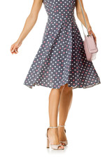 pink women's shoes and leather bag. Beautiful female legs wearing summer high heeled sandals in polka-dot dress and pink woman handbag on white background.