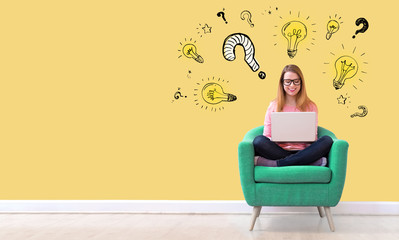 Question with light bulbs with young woman using her laptop in a chair