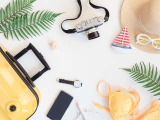 Fototapeta na wymiar top view travel concept with bikini, luggage and Outfit of traveler on white wooden background, Tourist essentials, vintage tone effect