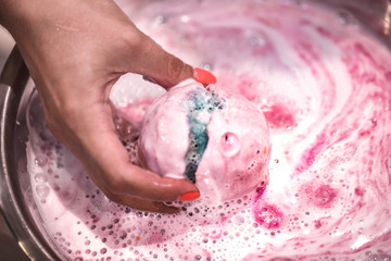 Bright natural fizzy bath bomb dissolves in the hands