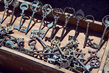many old keys lie on a wooden base