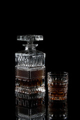 Bottle and glass of scotch on a dark background