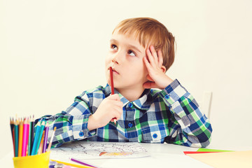 Cute little boy draws picture with pencils at art class. Happy kid has new idea. Education,...