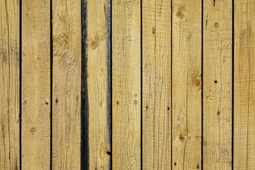 Old shabby yellow wooden fence texture