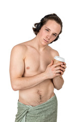 Handsome naked young man in towel listening to music in headphones on white background isolated