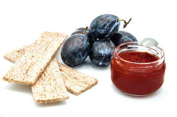 Plum jam without added sugar and diet wheat bread on an isolated background.
