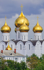 Assumption cathedral golden domes, with green trees and grey clouds background, Yaroslavl, Russia