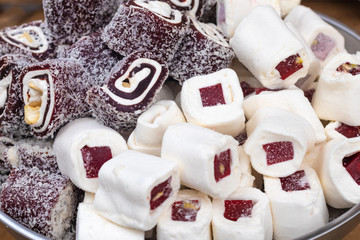 Eastern sweetness Turkish delight rolls with nuts and coconut. Turkish sweets on a round tray...