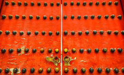 Wooden antic red door close-up as background.