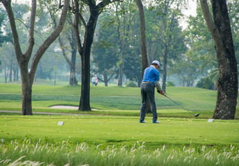 Shot of a male golfer teeing off with the ball in mid air on a bright sunny day, on the club.