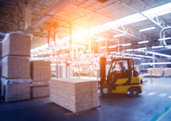 Obraz na płótnie Canvas Bloored background of forklift loader in storage warehouse ship yard. Distribution products. Delivery. Logistics. Transportation.
