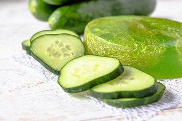 Sliced cucumber and soap on a white background. Home body care cucumber and care concept.