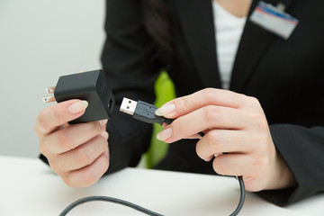 USBケーブルを触る女性