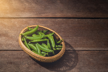 Fresh green peas or beans on wooden table