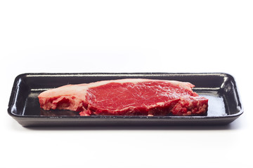 raw beef steak in vacuum package on