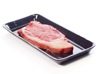 raw beef steak in package on white