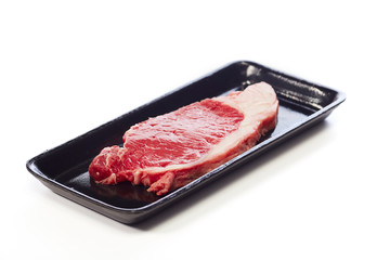 raw beef steak in  package on white