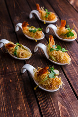 Crispy Shrimp in Kataifi Crust and Thyme on a woody background. Top view