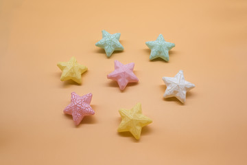 Fototapeta na wymiar Beautiful colorful toy stars neatly placed on a warm background, festive stars background