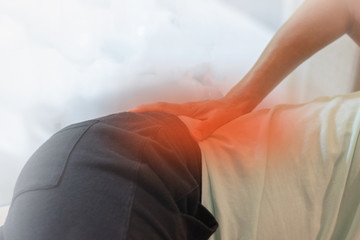 Hip joint pain concept. Man hand on his low back with red spot as suffer from injury or arthritis