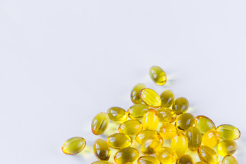 Top view of pile of colorful yellow capsules on white background. Pharmaceutical industry or drugs concept. Dose of medication in hospital. Healthcare product, dietary supplement. Copyspace