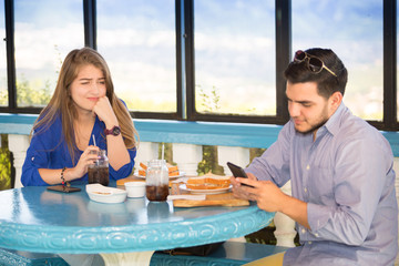 Couple during lunch at a park outdoors and she is bored because her friend is always paying...