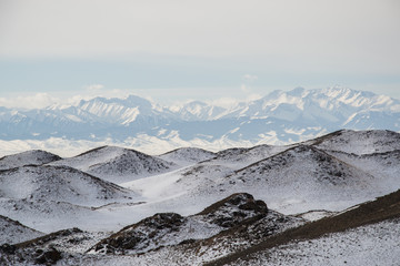 Snowy hills with mountains on the background