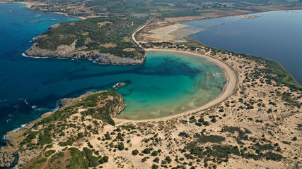 Naklejka premium Aerial drone view of semicircular sandy beach and lagoon of Voidokilia, one of the most iconic beaches in Mediterranean sea, with crystal clear turquoise sea, Messinia, Greece
