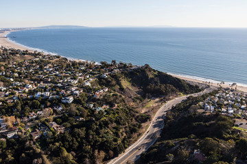 Aerial view of Temescal Canyon Road, Pacific Palisades homes and Santa Monica Bay in Los Angeles, California.