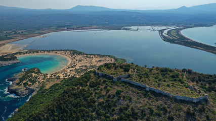 Aerial drone view of semicircular sandy beach and lagoon of Voidokilia, one of the most iconic beaches in Mediterranean sea, with crystal clear turquoise sea, Messinia, Greece