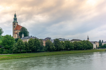 Fototapeta na wymiar The Salzach river flowing in Salzburg in Austria and its riverside