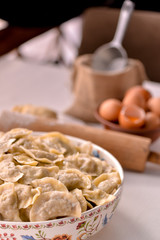 ready-made dumplings Ukrainian national dish in a painted dish on a board with ingredients of eggs and flour