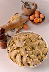 ready-made dumplings Ukrainian national dish in a painted dish on a board with ingredients of eggs and flour