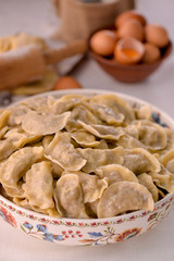 ready-made dumplings Ukrainian national dish in a painted dish on a board with ingredients of eggs and flour