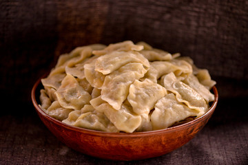 dumplings in a large clay dish on a dark background