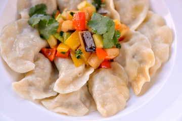Dumplings are ready in a white plate with vegetables