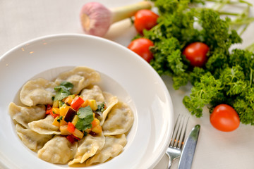 Dumplings are ready in a white plate with vegetables