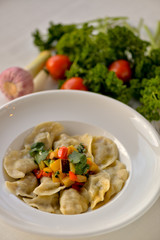 Dumplings are ready in a white plate with vegetables