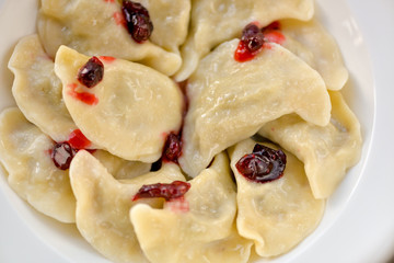 dumplings ready in a white plate with berries