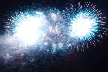 Light blue bright festive fireworks on the background of the night sky.