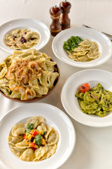many different vareniki in plates on the table