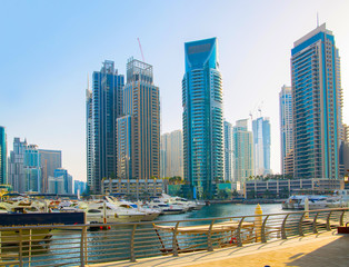Fototapeta na wymiar Dubai, UAE United Arabs Emirates. Dubai marina skyscrapers and yachts at sunset. Apartments, hotels and office buildings, modern residential development of UAE